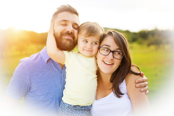 Family hugging in a meadow